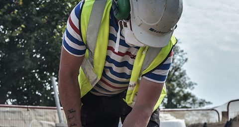 Health and Safety on Mackoy Civil Engineering Site with a Groundworks Operative cutting Slabs while wearing all Safety Equipment