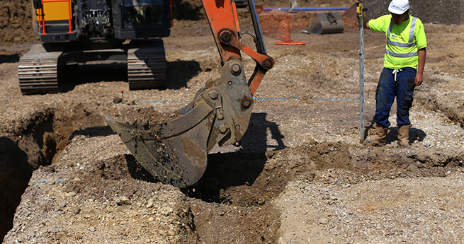 Mackoy Plant Machinery Excavator Digging Foundations with Groundworks Operative Supervising