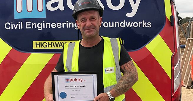 July Site Manager Award Winner in Front of Branded Mackoy Ltd Groundworks and Civil Engineering Van