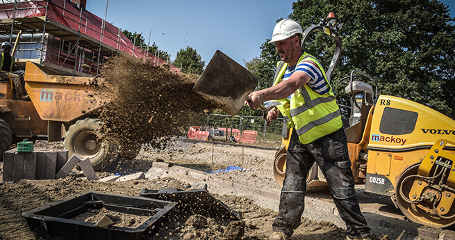 Mackoy Groundworker Shovelling Soil to Prepare Site for Trench Digging