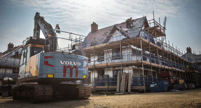 Mackoy Groundworks Excavator in front of semi-finished house